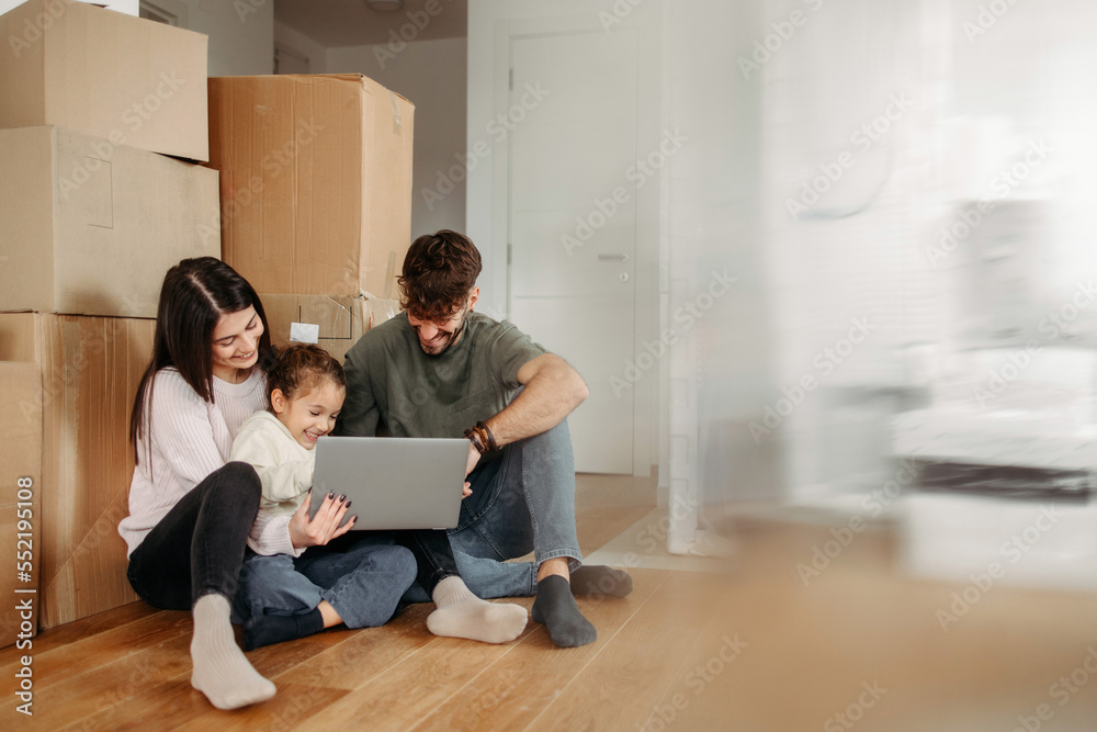 Young cheerful family making selfie in their new home surrounded with unpacked cardboard boxes Young cheerful family making selfie in their new home surrounded with unpacked cardboard boxes