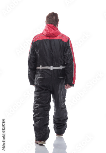 man in a winter insulated jumpsuit reading walking forward
