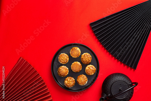 Chinese moon cakes on a black plate on a red background
