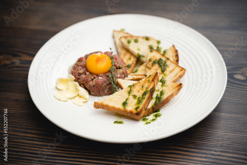 a tasty dish of meat and egg yolk with croutons on a plate.