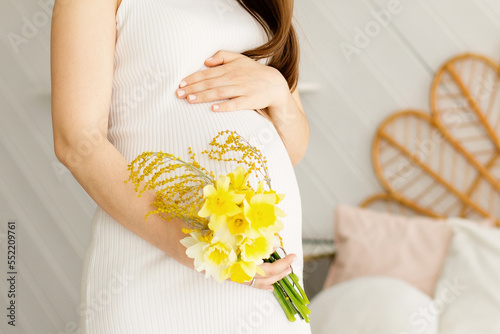 Image of pregnant woman touching her belly with hands
