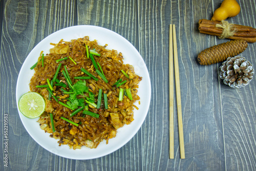 Stir fried noodles thai korat style or pad mee korat topping with spring onions and coriander is the food of northeast thai people, similar to pad thai but the recipes and seasonings are not the same. photo