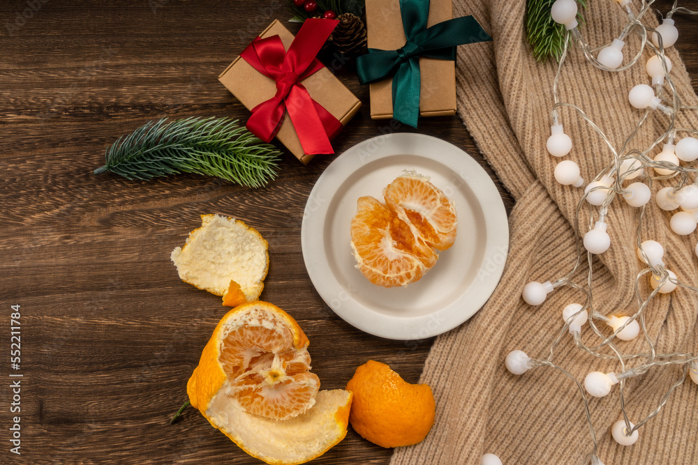 christmas concept with Tangerines, presents, Fir, scarf, lights, on wooden background