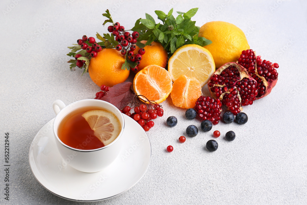 Cup of delicious immunity boosting tea with ingredients on light grey table Cup of delicious immunity boosting tea with ingredients on light grey table