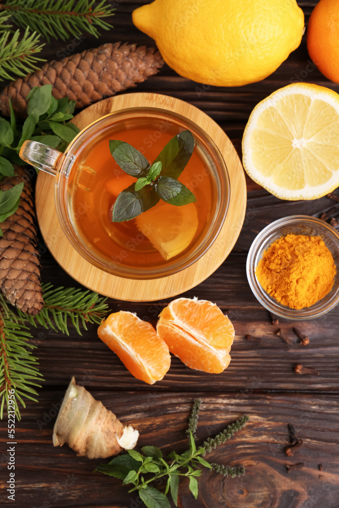 Flat lay composition with glass cup of delicious immunity boosting tea and ingredients on wooden table Flat lay composition with glass cup of delicious immunity boosting tea and ingredients on wooden table
