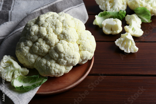 Plate with fresh raw cauliflower on wooden table