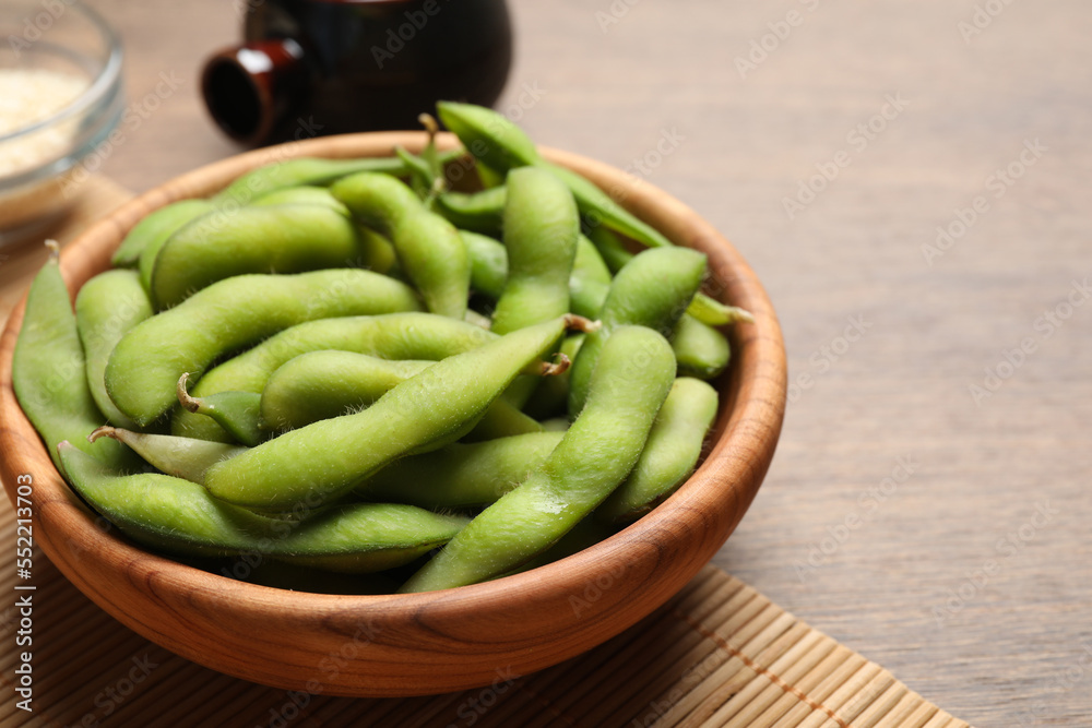 Green edamame beans in pods served on wooden table. Space for text Green edamame beans in pods served on wooden table. Space for text