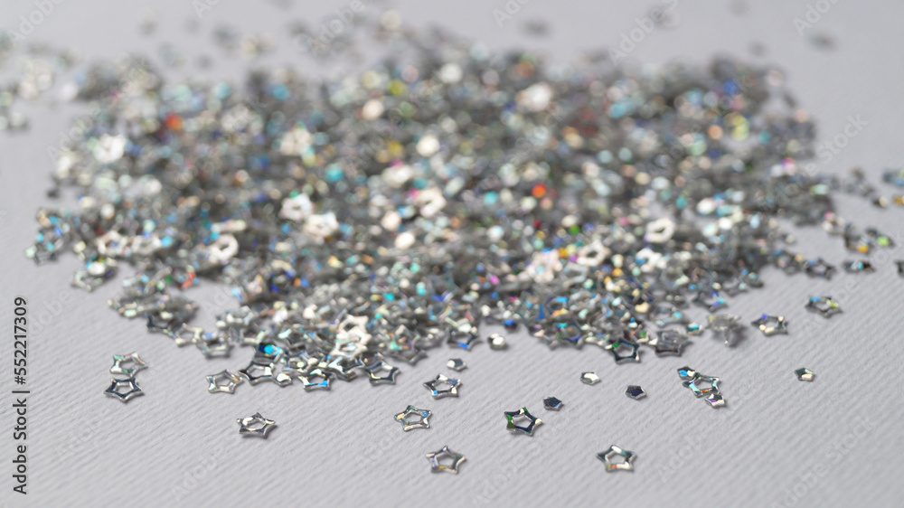 Pile of silver star shaped sequins on white background, closeup Pile of silver star shaped sequins on white background, closeup