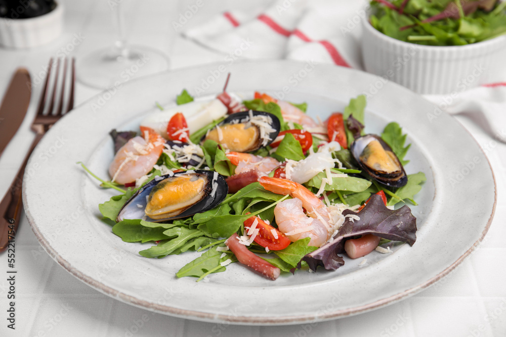 Plate of delicious salad with seafood on white tiled table, closeup Plate of delicious salad with seafood on white tiled table, closeup