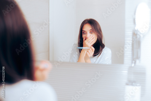 Happy Woman Checking Pregnancy Test in the Bathroom. Cheerful mother to be checking medical test result at home
 photo