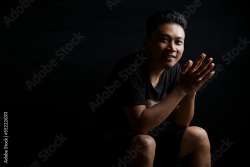 young asian man portrait smiling isolated black background