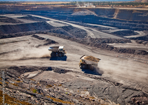 Two diesel-electric trucks used in modern mines and quarries for hauling industrial quantities of ore or coal. Used when extra torque is needed for steep hills. Blackwater, Australia. Logos removed.
