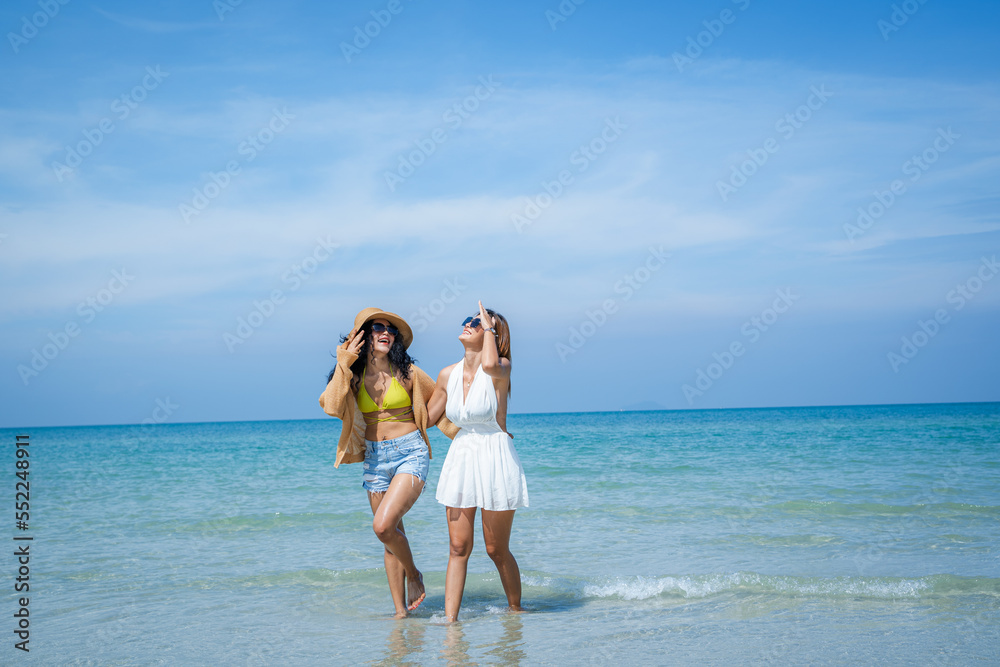 Two attractive girls jumping on the beach,Having Fun,Summer Lifestyle.