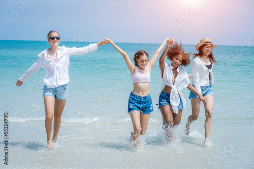 Young women and friends playing at the beach on a sunny day,Happy friends together at the beach.