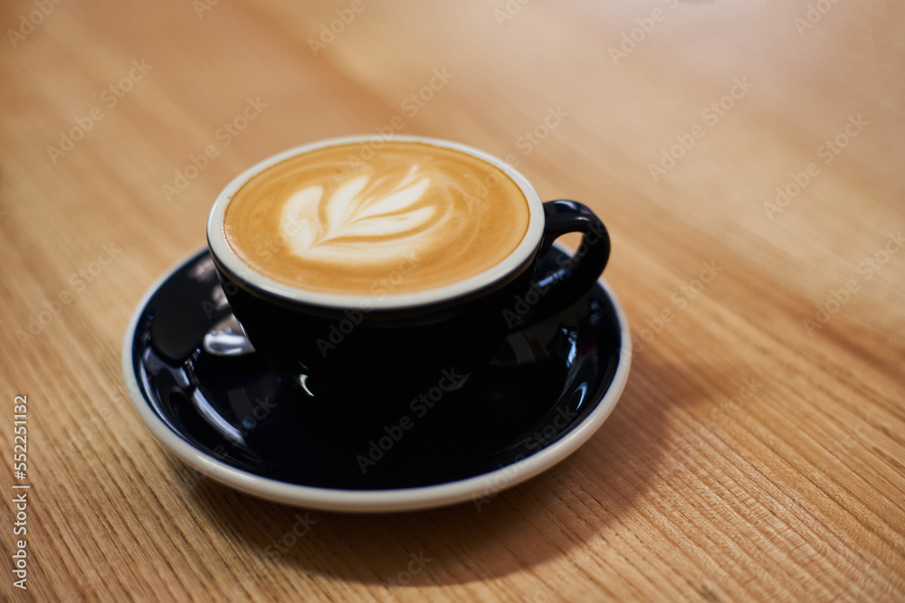 Cup of coffee on the table in cafe. Cappuccino or latte in mug. Enjoying time alone Cup of coffee on the table in cafe. Cappuccino or latte in mug. Enjoying time alone