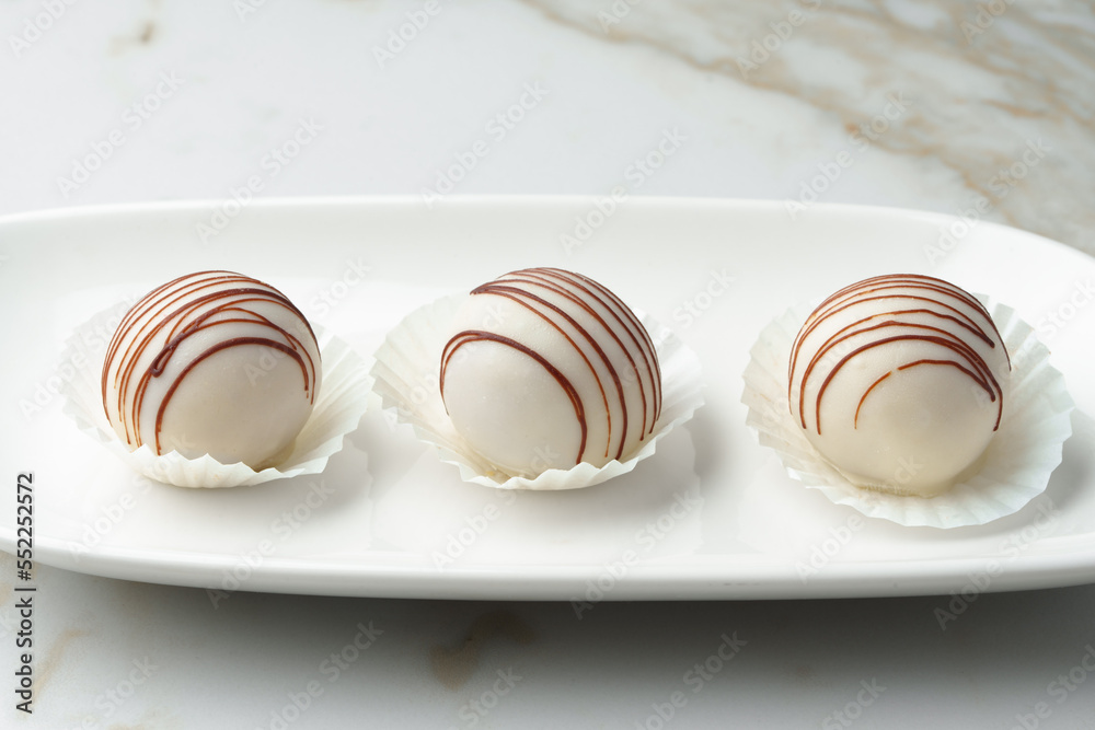 White chocolate candy on white plate close up White chocolate candy on white plate close up