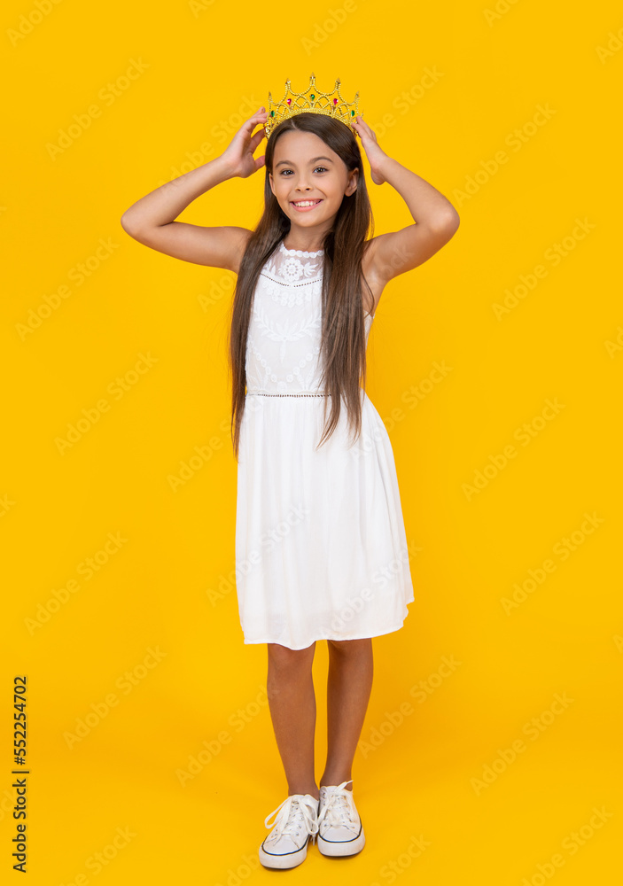 smiling teen kid in crown on yellow background