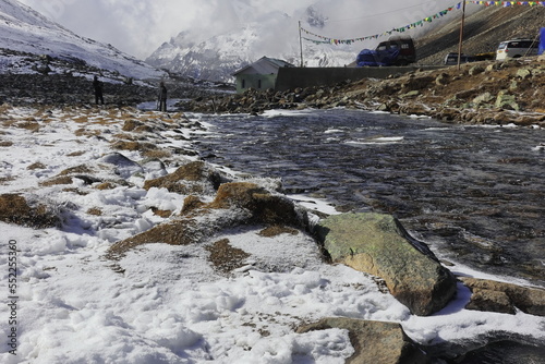scenic mountain landscape and snow covered river valley at zero point or yumesodong, surrounded by snow clad himalaya mountains in north sikkim, india