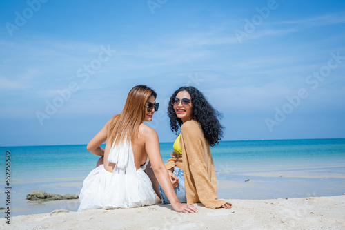 Two women playing together in the sea at the beach.