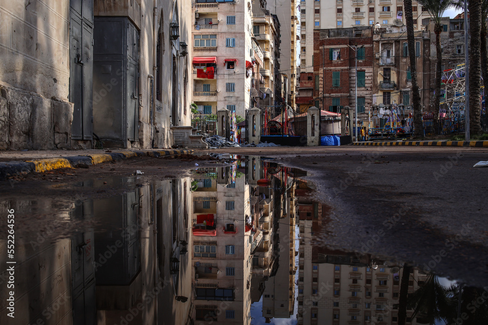 Naklejka premium Street view with water reflection after rain. Summer Rain Showers, urban view.