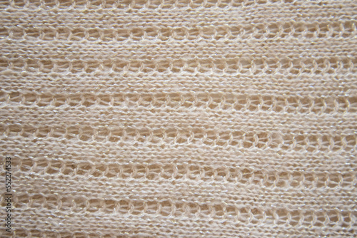 Soft beige knitted fabric as background, closeup. Openwork knitting, horizontal direction. Copy space for text. Design for text. Directly Above View.