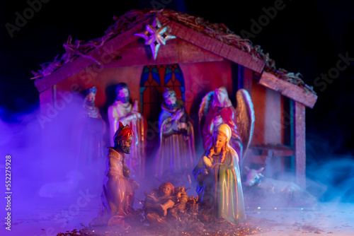 Christmas birth of Jesus. Christmas manger scene with figurines including Jesus, Mary, Joseph, lamb. Biblical Mary holding baby Jesus. Christmas theme.