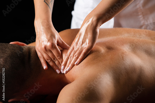 фотографія Massage for man. Physiotherapist massaging male shoulder.