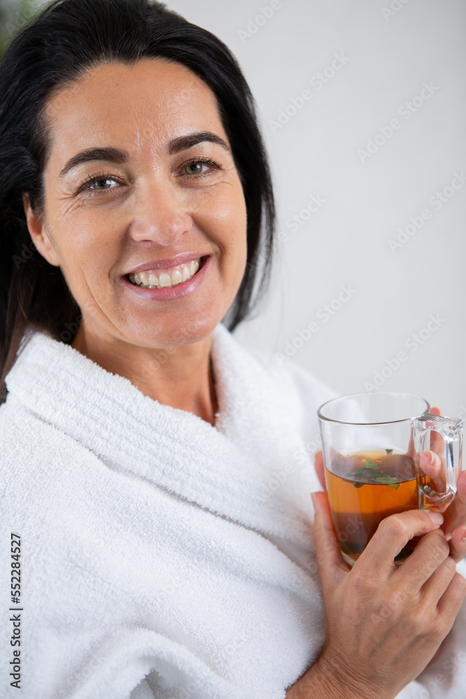 nice smiling senior in bathrobe enjoying a cup of tea nice smiling senior in bathrobe enjoying a cup of tea