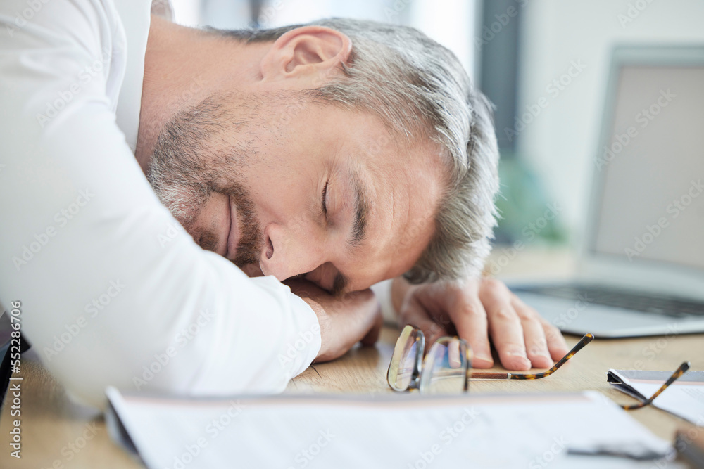 Burnout, sleeping and tired business man at his desk for financial report, audit or tax documents with time management fail or mental health risk. Fatigue, depression and sad businessman in workplace Burnout, sleeping and tired business man at his desk for financial report, audit or tax documents with time management fail or mental health risk. Fatigue, depression and sad businessman in workplace