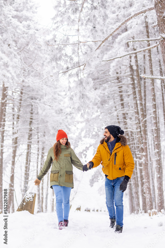 Couple walking in the snow while on winter vacation