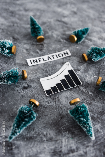Fototapeta Naklejka Na Ścianę i Meble -  Inflation graph with stats going up surrounded by mini Christmas trees, cost of living rising during the 2022 festive season