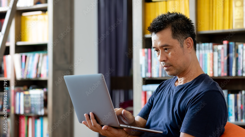 Asia man using device in the library Asia man using device in the library