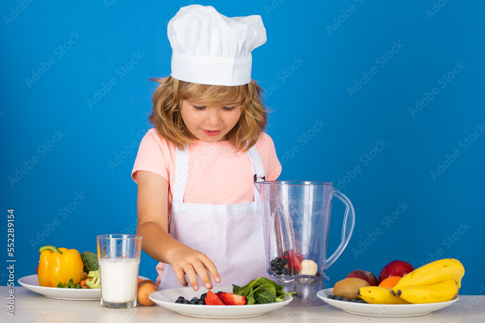 Child chef dressed cook baker apron and chef hat isolated on studio background. Healthy nutrition kids food. Child chef dressed cook baker apron and chef hat isolated on studio background. Healthy nutrition kids food.