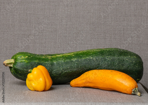Big green zucchini, yellow zucchini, yellow pepper, paprika on a gray background. Proper nutrition. Food. Vegetables. Restaurant. Score. Vegan. Gourmet. Healthy food.