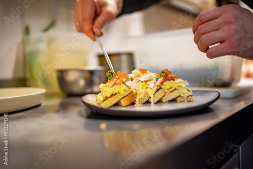 chef cooking brioche with scrambled eggs, caviar and crab meat on kitchen © pavel siamionov