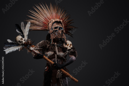 Quadro su tela Shot of aztec witch dressed in ceremonial headdress holding staff with skull