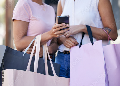 Smartphone, shopping bag and women or friends with website sale, online discount or promotion deal with e commerce, fintech or mobile app. Outdoor, shopping and people hands using phone for ecommerce