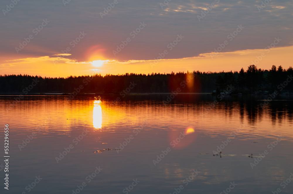 Sunrise in the cloudy sky over the water surface