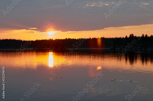 Sunrise in the cloudy sky over the water surface