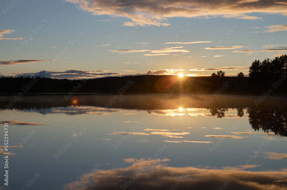 Sunset in a cloudy sky over the water surface