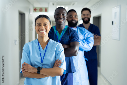 Portrait of diverse group of smiling healthcare workers standing in line in hospital corridor