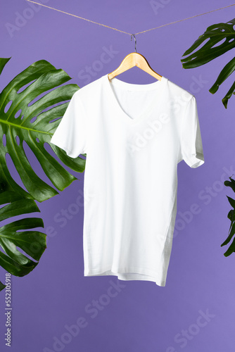 Tshirt hanging on coat hanger and copy space on purple background