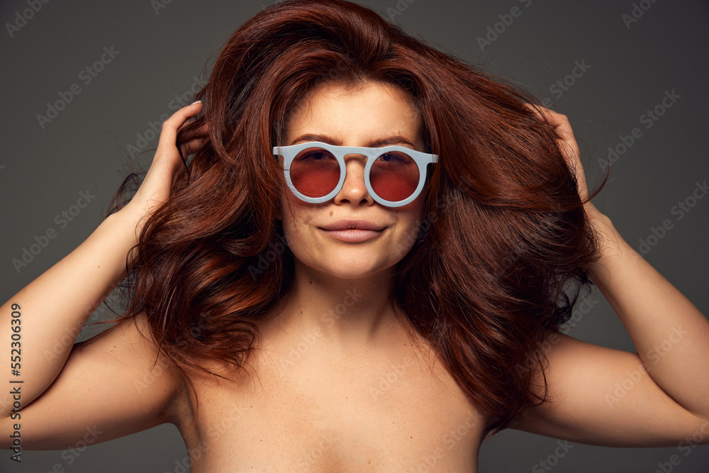 Portrait of young beautiful red-haired woman with perfect hairstyle isolated on dark grey background. Mega hair volume Portrait of young beautiful red-haired woman with perfect hairstyle isolated on dark grey background. Mega hair volume