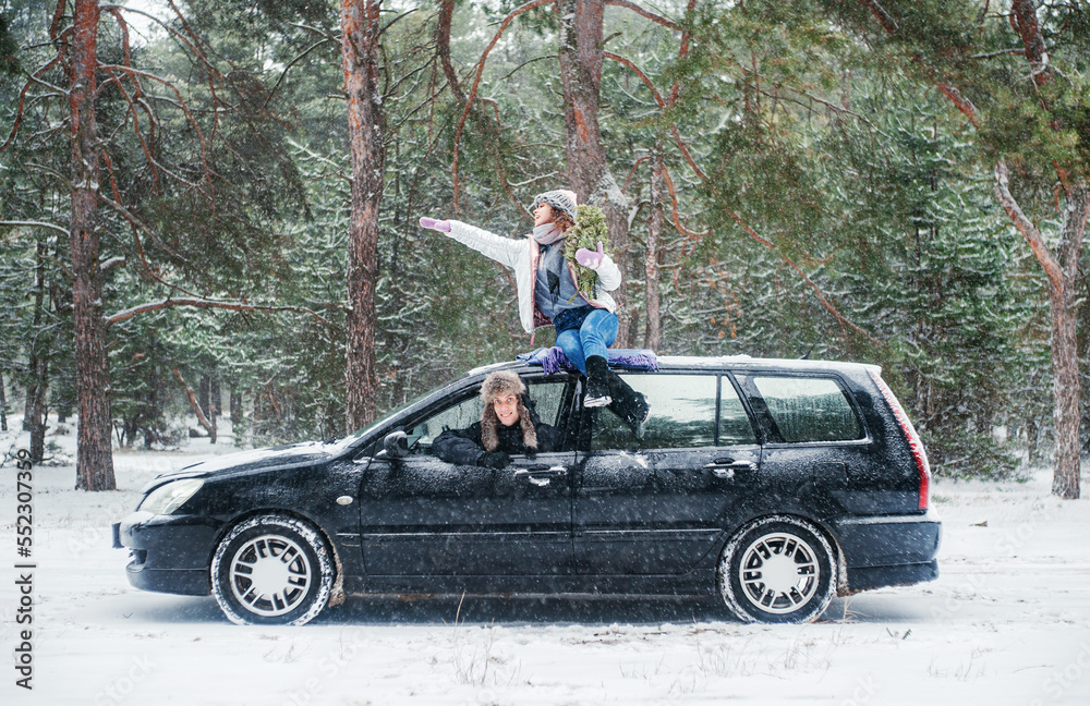 Happy couple traveling by car in the winter. Woman and man walking in winter forest. Happy couple traveling by car in the winter. Woman and man walking in winter forest.