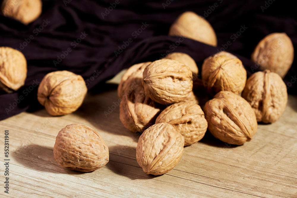 Close-up of tasty in-shell walnuts on wooden table
