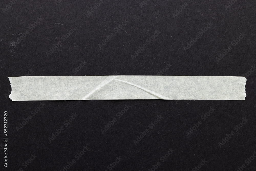 Ripped up piece of masking tape with copy space on black background Ripped up piece of masking tape with copy space on black background