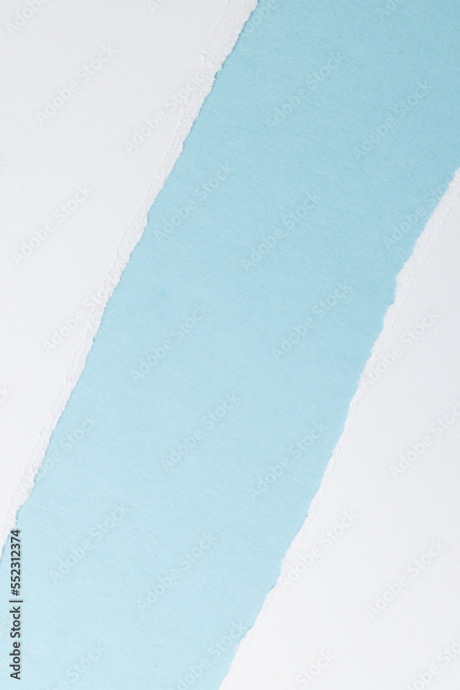 Ripped up pieces of white paper with copy space on blue background