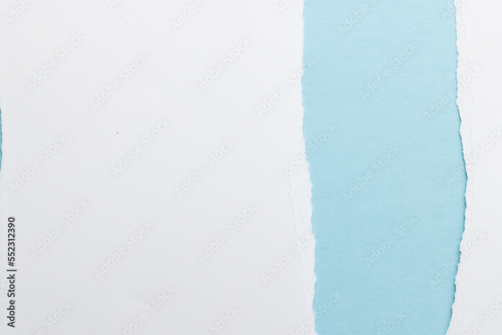 Obraz premium Ripped up pieces of white paper with copy space on blue background