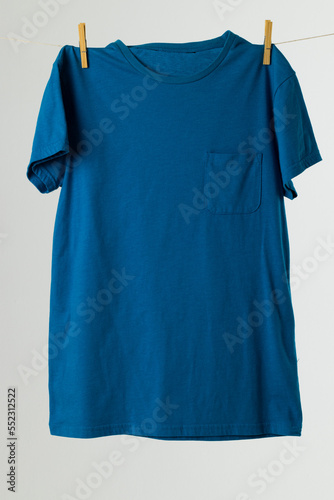 Close up of hanging blue tshirt and copy space on white background