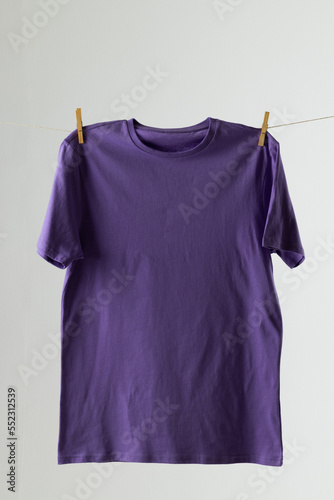 Close up of hanging purple tshirt and copy space on white background